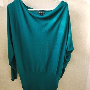 Long green sweater with gold zippers on shoulders.